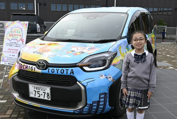 県知事賞を受賞した国定さんと自身の作品などがラッピングされた車両＝１日午前、宇都宮市インターパーク６丁目