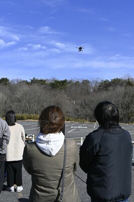 物資を備えて移動するドローン（中央上）＝那須町