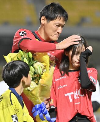 涙ぐむ子供たちの頭をなでる丹野