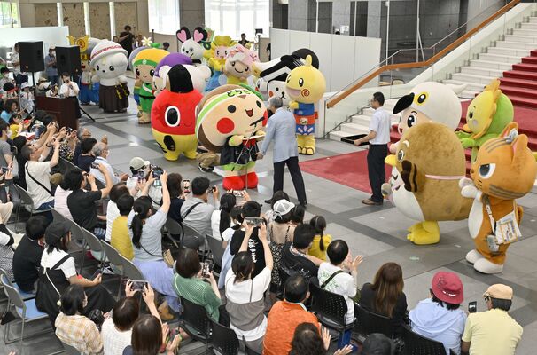 大勢の来場者や県内各地のゆるキャラが見つめる中、福田知事から辞令を交付されるとちまるくん（中央）＝15日午後１時30分、県議会議事堂