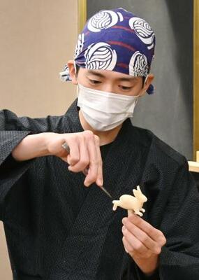 　はさみを使ってウサギを作るあめ細工職人＝東京都台東区