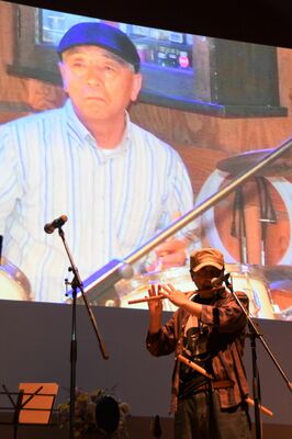 嶽本さんの写真を背に演奏するＡｓｈさん