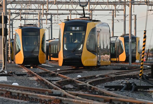 開業を目前に控え、朝日を受けながら試運転へ出発するＬＲＴ＝24日午前５時20分、宇都宮市下平出町