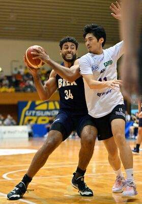 第１Ｑ２分、ブレックスのジェレット（左）がゴール前で競り合う＝ＦＵＫＡＩ　ＳＱＵＡＲＥ　ＧＡＲＤＥＮ足利