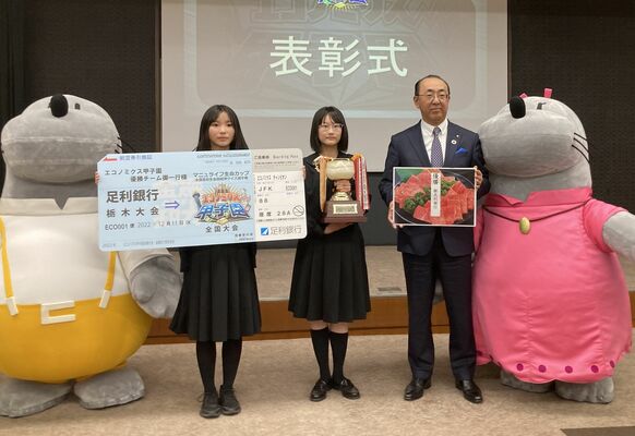 清水頭取（右）からトロフィーなどを贈られた小林さん（左）と黒崎さん＝宇都宮市