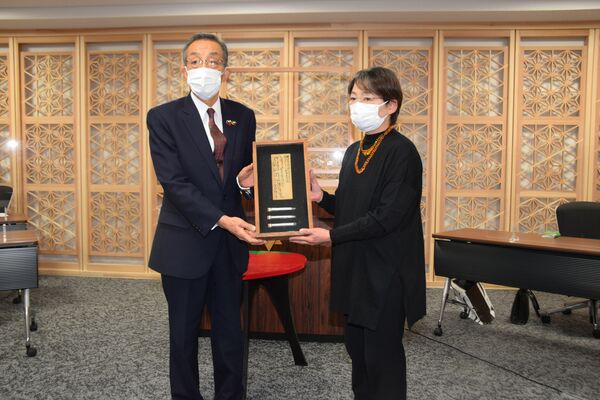 佐藤市長（左）から木札を手渡された瓦井紀子さん