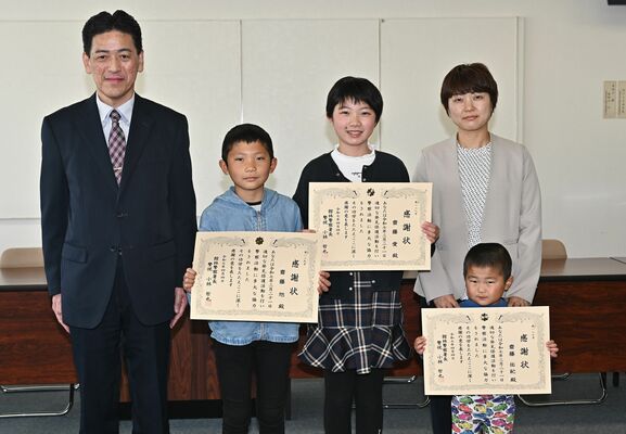 感謝状を受け取った右奥から佑紀さん、愛さん、旭さん。手前は次男の慶ちゃん