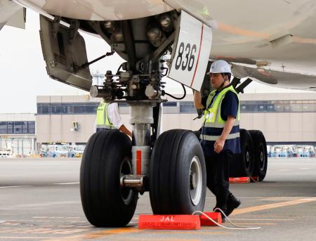 　成田空港の駐機場で機体チェックをする国交省の担当者ら＝８月８日
