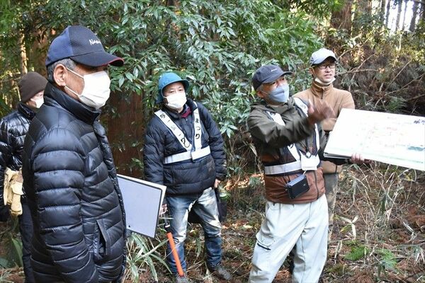 山林の中に残る江戸堀跡について説明する学芸員（右から２人目）