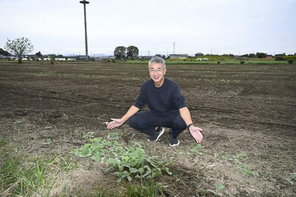 収穫後の畑で手応えなどを語る岩田さん