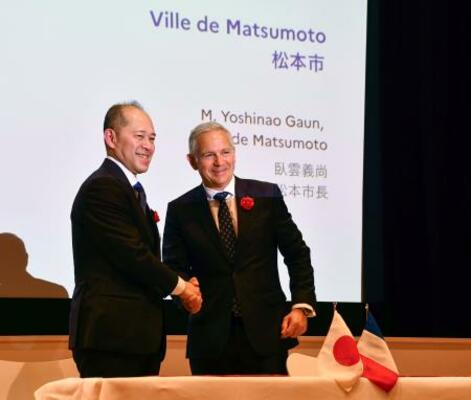 　握手する長野県松本市の臥雲義尚市長（左）とシャンボール国立公園トップのピエール・デュブルイユ氏＝１日午後、東京都港区