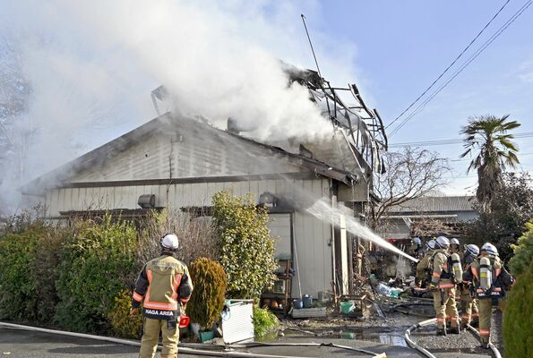 煙を上げる住宅の火災現場＝21日午前10時35分、芳賀町稲毛田