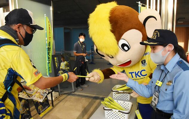 来場客に反射材を手渡すトッキーら