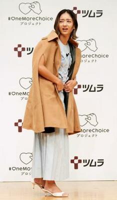 　生理による倦怠感を疑似体験するコートを羽織った池田美優＝７月２４日、東京都千代田区