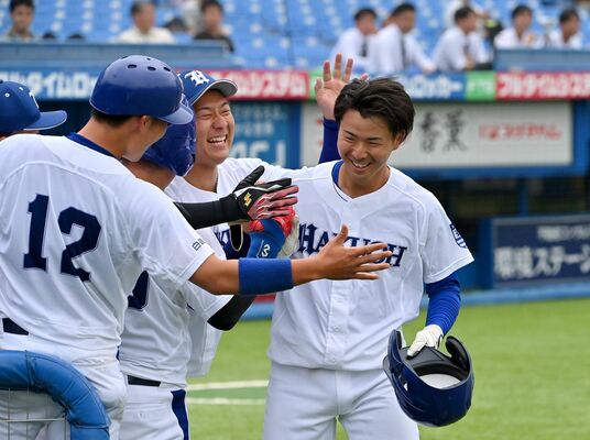 ８回、決勝点となる本塁打を放ち、ベンチで祝福を受ける白鴎大の浅野（右）＝神宮球場
