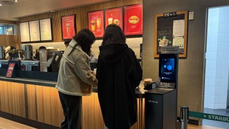 　ソウル市内のスターバックス店内で、専用食洗機を使ってタンブラーを洗う女性客＝２月１２日
