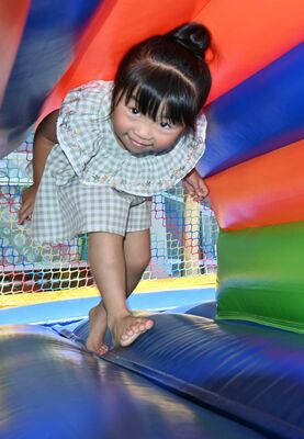 「ふわふわジャンボエアーポリン」内のトンネルをくぐる子ども