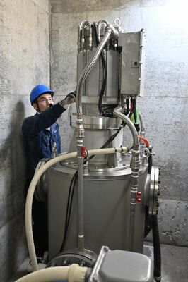 開所式後にマイクロ水力発電の設備を説明するDK-Powerの担当者＝23日午後、那須塩原市