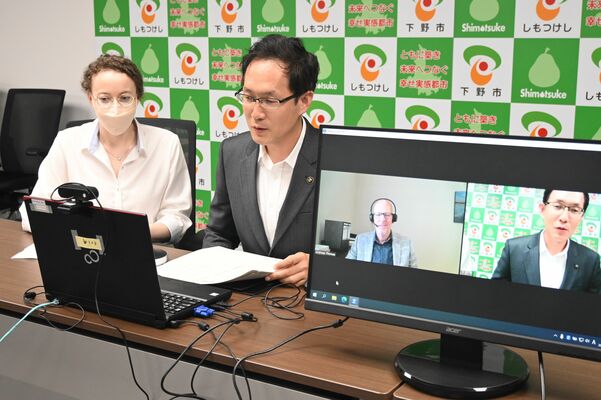 祝意を伝える坂村市長と、トーマス市長（画面左）