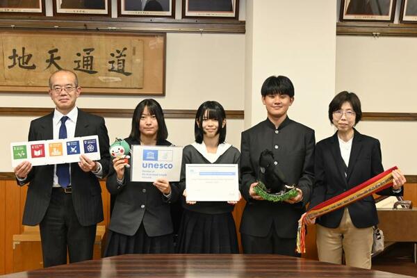 ユネスコスクールの認定証などを手にする生徒ら