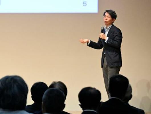 　不登校への取り組みを紹介する、文科省生徒指導室の上久保秀樹室長補佐＝１４日午前、宇都宮市