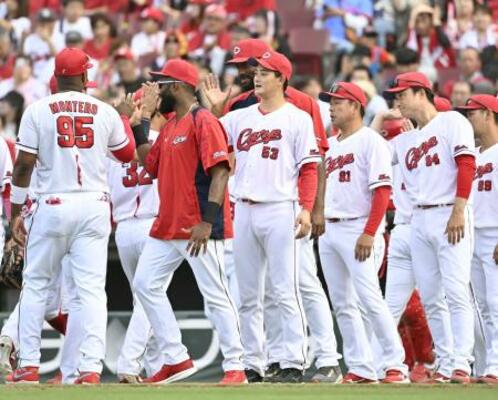 　７回２失点で４勝目を挙げ、ナインとタッチする広島・岡本（中央）＝マツダ