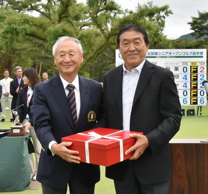 松本大会会長（左）から副賞を受け取る羽川＝日光ＣＣ