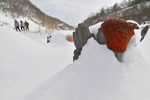 殺生石の遊歩道脇に並ぶ雪に埋もれた千体地蔵=10日午後0時30分、那須町湯本