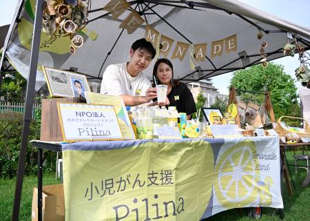 　小児がん患者支援のためにレモネードを販売する土井颯大さん。右は活動を支える母のかおりさん＝大阪市鶴見区