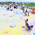秋に開通予定の上三川・栄橋がキャンバスに　本郷小児童ら、チョークで一面カラフルに染める