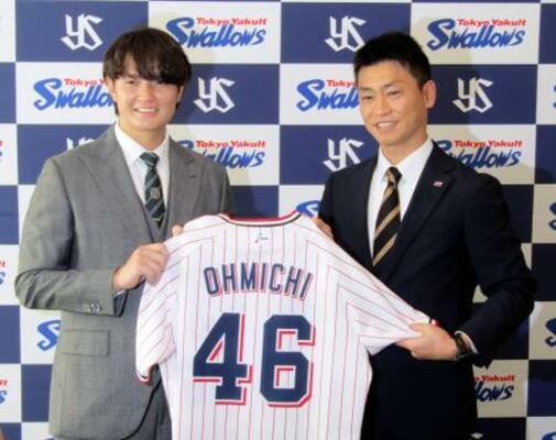 　ヤクルトへ移籍し、青木ＧＭ特別補佐（右）と写真に納まる大道＝１７日、神宮球場