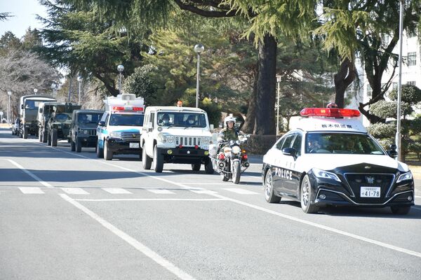 緊急輸送訓練で宇都宮駐屯地を出発する県警のパトカーや自衛隊車両＝６日午後、宇都宮市茂原１丁目
