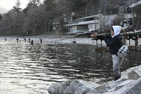 水位の下がった岸辺で釣りを楽しむ人たち＝１日午前７時５分、日光市中宮祠