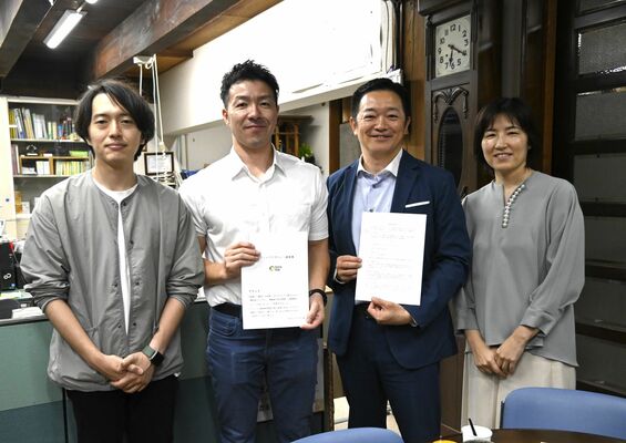 契約書を手にする為永代表理事（左から２人目）、塚本代表取締役（同３人目）ら