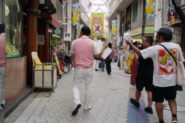 商店街を歩くオードリー春日。足取りが軽く、気を抜くと置いて行かれそうになる。