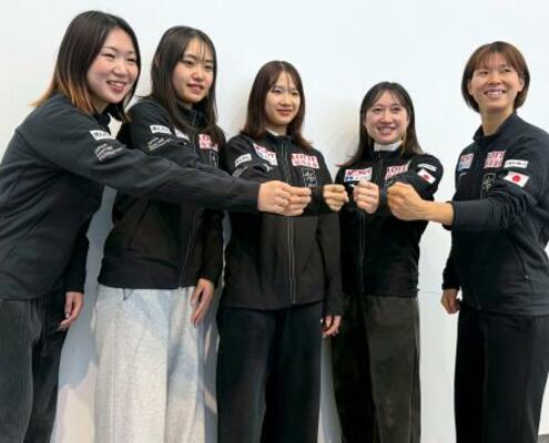 　帰国し、写真撮影に応じる中島未莉（中央）らスピードスケート・ショートトラックの日本勢＝２日午後、成田空港