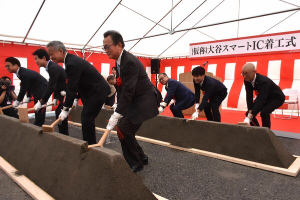 着工式でくわ入れする関係者ら