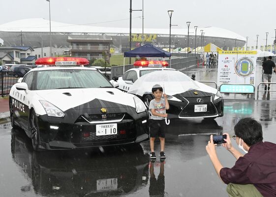 パトカーの前で記念撮影する来場者＝14日午後、宇都宮市西川田４丁目