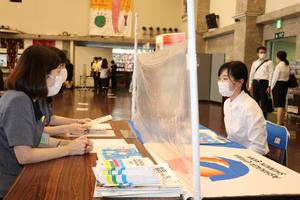 企業の説明を笑顔で聞く学生