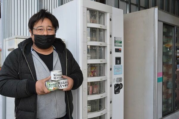馬頭高生の缶詰が収まる自販機と手塚さん