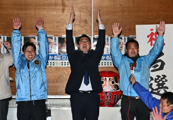 初当選が決まり、支持者と万歳する杉田光氏（中央）＝９日午後10時50分、足利市上渋垂町