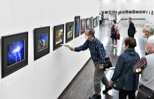 しもつけ写真大賞の入選作品に見入る来場者＝13日午前、宇都宮市本町