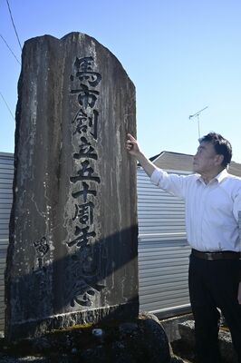 馬市主催事務所50周年を記念した石碑を眺め、当時のにぎわいに思いをはせる小口会長