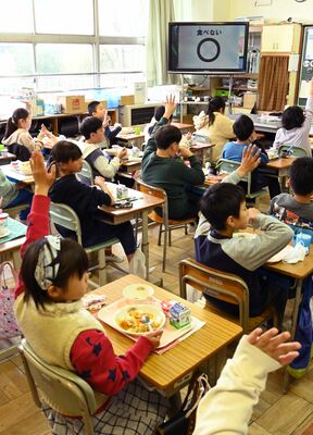 挙手してクイズに答える児童たち