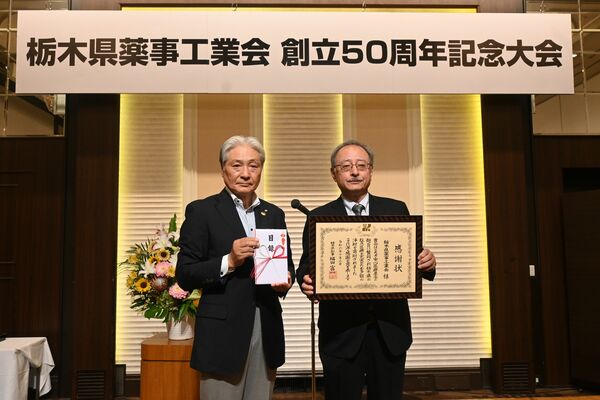 福田知事（左）に目録を手渡した富永会長＝２日午後、宇都宮市内