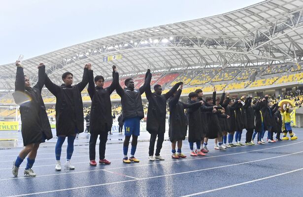 勝利を収め、サポーターに両手を掲げてあいさつする栃木SCの選手たち=カンセキスタジアムとちぎ、広瀬華撮影