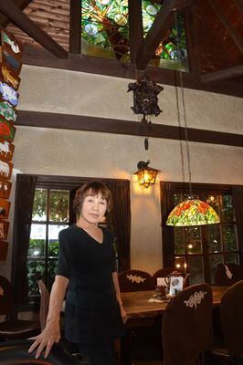 吹き抜けのある店内に立つ山本さん。内装や家具類は半世紀前とほとんど変わっていない