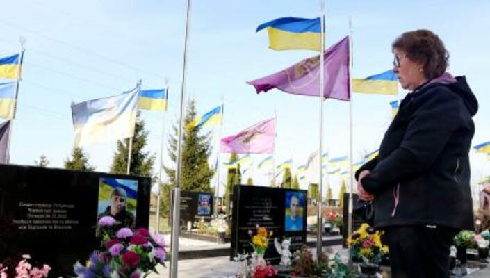 おいのロマンさんの墓を訪れたジナイダ・ネドレンコさん=30日、ウクライナ・ブチャ(共同)