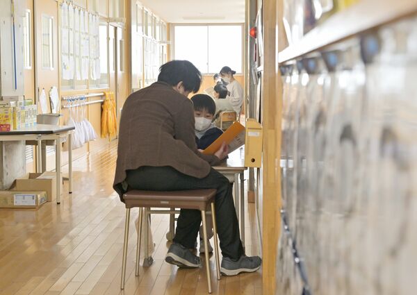 廊下で一人一人と面談し、通知表を手に２学期を振り返る各クラスの担任教諭＝25日午前11時15分、足利市福富町