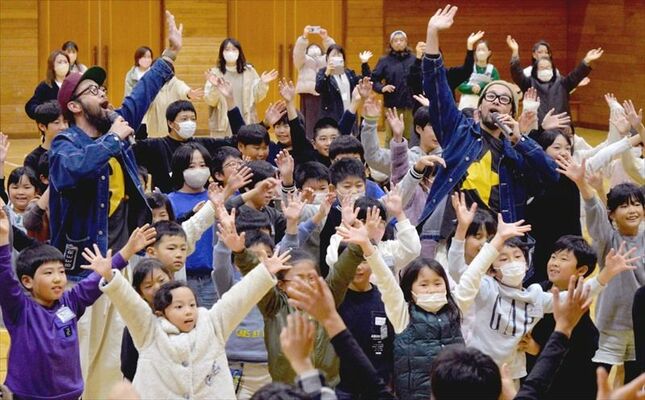 踊りながら歌う上鈴木兄弟と児童たち